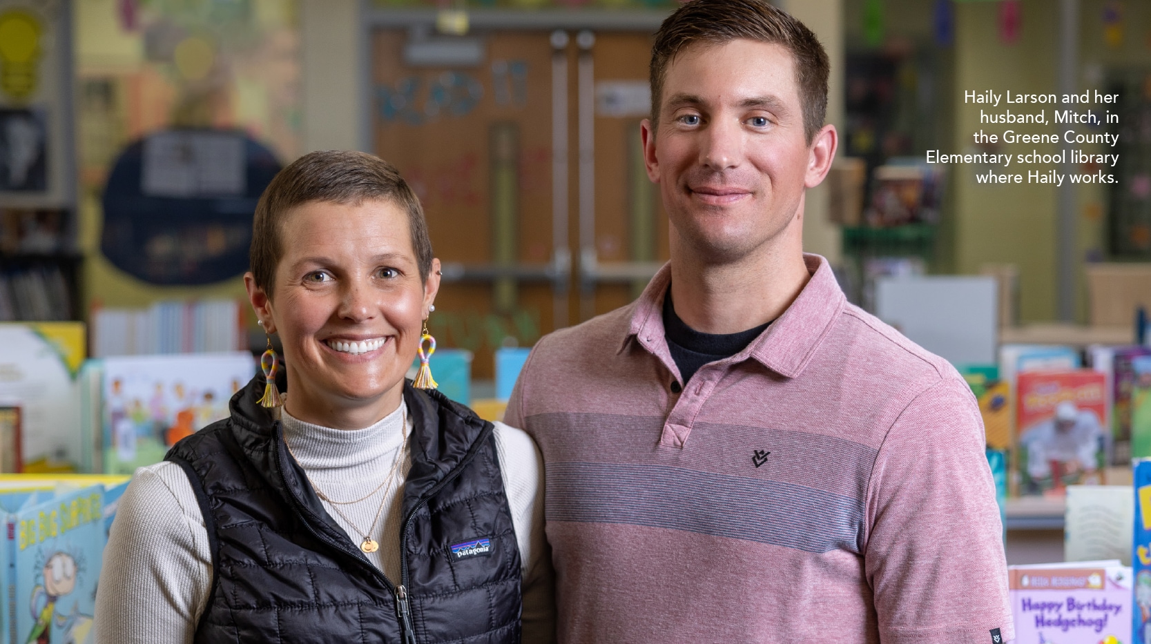 Haily Larson and her husband, Mitch, in the Greene County Elementary school library where Haily works. 