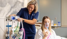 Birthways nurse assisting a patient using a mask to inhale nitrous oxide. 